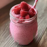 W kielichu malinowy koktajl z nasionami chia, zawierający mleko, mleczko, jabłka, chia seeds i raspberry syrup.